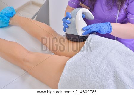 Young beautiful woman gets professional body shape treatment in a beauty clinic
