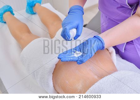Young beautiful woman gets professional body shape treatment in a beauty clinic