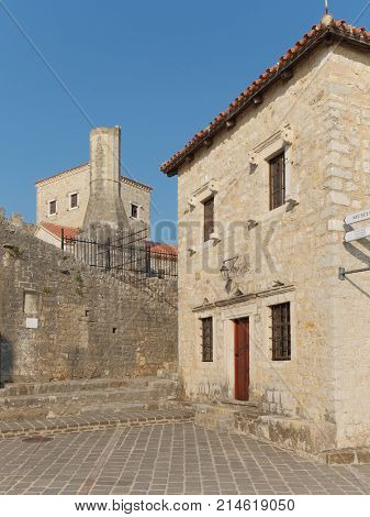 ULCINJ, MONTENEGRO - JULY 13, 2017: minaret of church-mosque and tower of the Balsic in Ulcinj Old Town, Montenegro