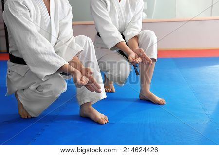 Young man and woman practicing karate in dojo