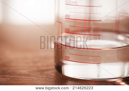 Measurements , measuring liquids. A measruing glassware or kitchen ware with water at 200ml line. Shallow depth of view.
