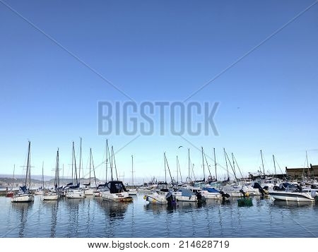 Lyme Regis, Dorset, United Kingdom. 21st August 2017. Sailing and speed boats in the harbour at Lyme Regis on a blue sky day in summer.