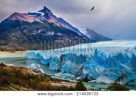 The colossal Glacier Perito Moreno on Lake Argentino in Patagonia. Argentine province of Santa Cruz. The cloudy sky covers the horizon. The concept of active and ecological tourism