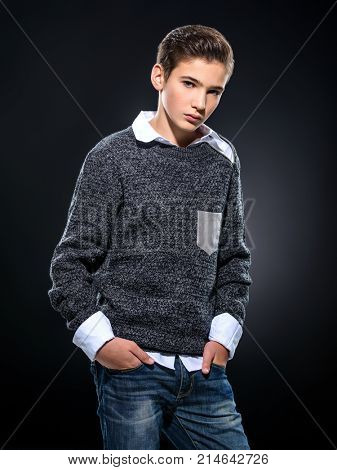 Photo of teenage handsome guy posing at studio. Fashion portrait of cute pretty teen boy