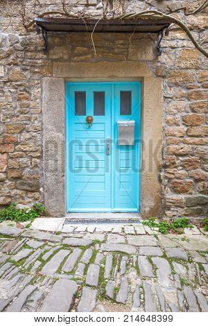 Blue Entrance Door With A Mailbox To A House On Stone Street In
