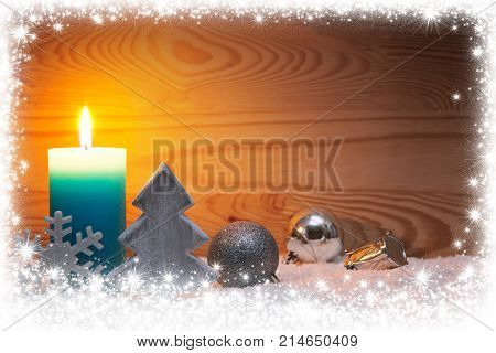 Avent candle and christmas decoration isolated on wood background. Christmas background with snow frame, candle and wood fir tree.