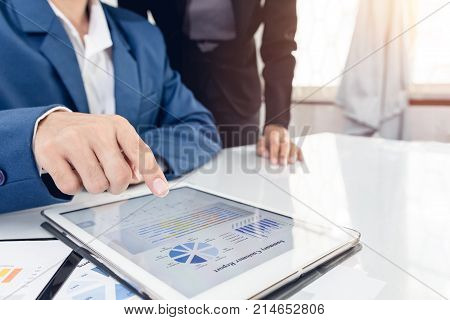 Investor executive pointing growth by graph and discussing plan financial graph data my team at office. Business team recheck summary or annual audit of financial information. Business team meeting.
