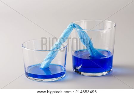 Physics. Capillary action. Dyed water is moving up through paper towel. 
