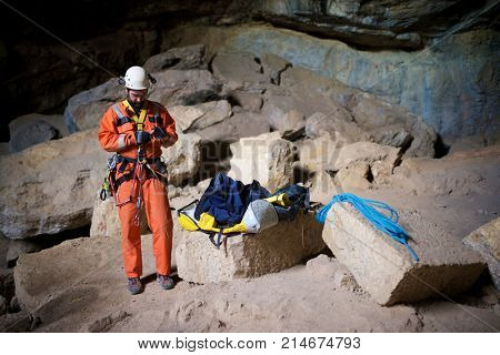 Speleologist performing rope maneuvers in a cave. Zaragoza Province, Aragon, Spain.