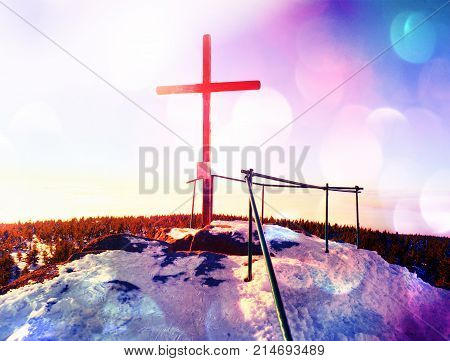 Cross Raised  At Mountain Summit. Sharp Peak, Daybreak Sun In Sky.
