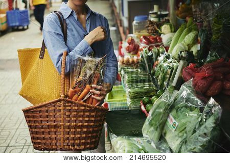 Cropped image of woman buying vegetables at street market