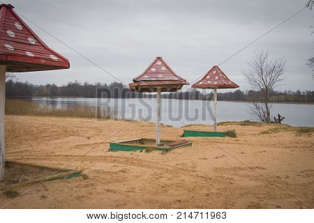 Beach Wooden Umbrellas On The Beach With A Red Roof.