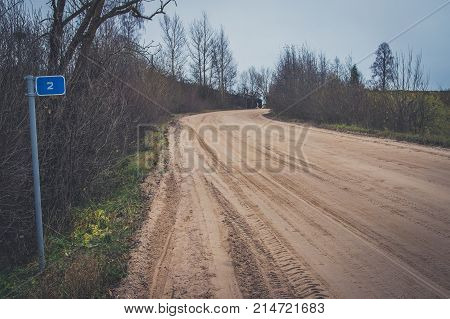 Sharp Turn With Warning Sign On A Gravel Road.