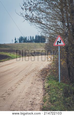 Sharp Turn With Warning Sign On A Gravel Road.