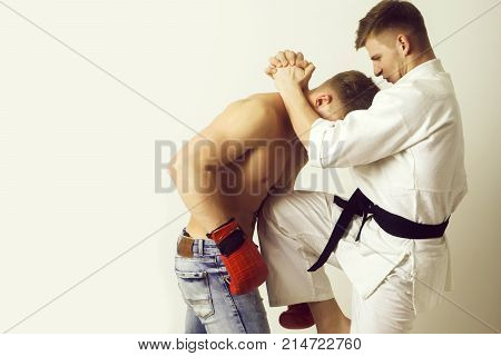 Karate Athlete In Kimono Kicking Knee At Boxer