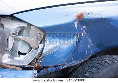 Car crash. Broken headlight in crash accident on damaged car with dented sheet selective focus