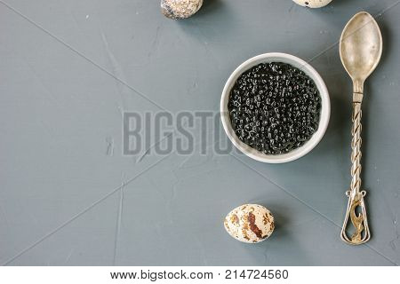 Top view of black caviar in white ceramic bowl