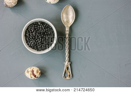 Top view of black caviar in white ceramic bowl