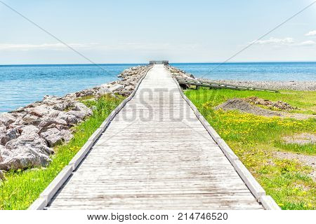 Empty Long Wooden Boardwalk With Nobody On Pier Dock Quay With Gulf Of Saint Lawrence River In Gaspe