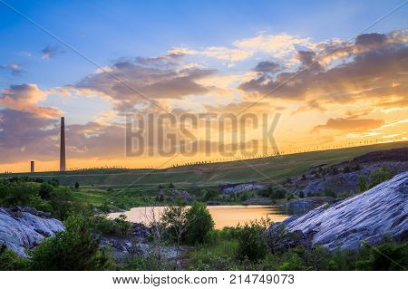 View of a smelter stack of a nickel plant showing the emission on the air with sunset sky as as background