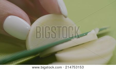 Young Female Hands Slicing White Onion. Woman Chopping Onions On Cutting Board With Knife. Woman Cut