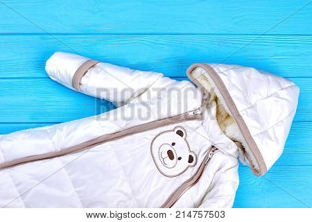 Baby high quality winter romper. Cute autumn winter flannel baby romper on blue wooden background.