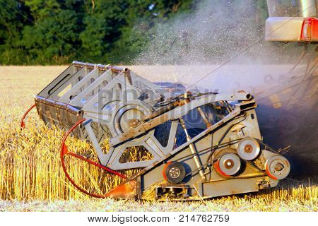 Combine machine is harvesting oats on farm field. combine harvester working on a wheat field. Combine harvester cuts the field of mature ripe yellow wheat