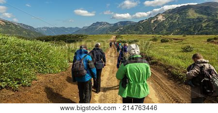 Kamchatka Peninsula, Russia - August 25, 2016: Group of tourists walks along the Viluchinsky pass