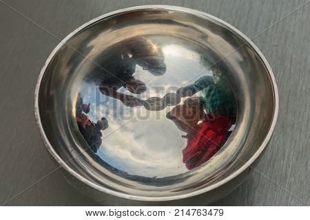 Reflection of a group of tourists in a marching steel plate