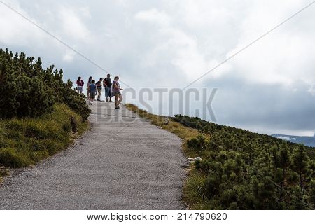 Obertraun, Austria - August 5, 2017:  Scenic view of path in the mountain with unidentified people hiking on background. Hoher Dachstein mountains in the Alps