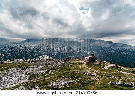 Obertraun, Austria - August 5, 2017:  Scenic view of alps mountains a sunny day with church on foreground. Hoher Dachstein mountains.