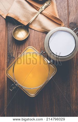 Desi Ghee or clarified butter in glass or Copper container or ceramic jar with spoon, selective focus