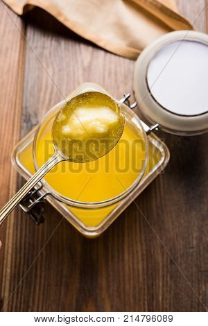 Desi Ghee or clarified butter in glass or Copper container or ceramic jar with spoon, selective focus