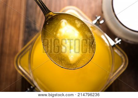 Desi Ghee or clarified butter in glass or Copper container or ceramic jar with spoon, selective focus