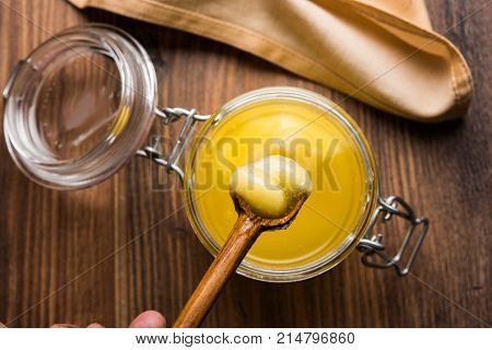Desi Ghee or clarified butter in glass or Copper container or ceramic jar with spoon, selective focus