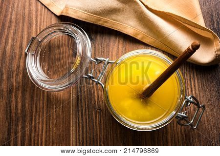 Desi Ghee or clarified butter in glass or Copper container or ceramic jar with spoon, selective focus
