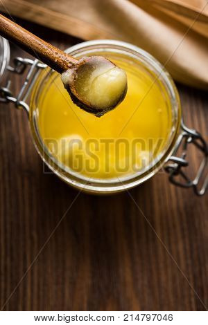 Desi Ghee or clarified butter in glass or Copper container or ceramic jar with spoon, selective focus