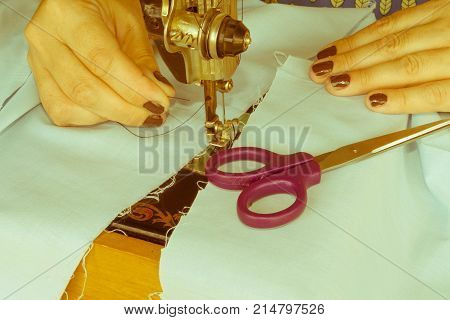 closeup of woman hands sewing yellow cloth outdoors. Woman's Hand Sewing Quilt