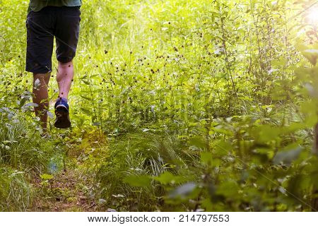 Feet of a young man walking along the path. Summer Spring Autumn.