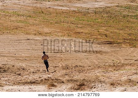 A young man runs through the desert