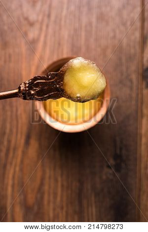 Desi Ghee or clarified butter in glass or Copper container or ceramic jar with spoon, selective focus