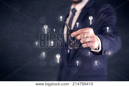 Businessman in suit holding keys with keys graphics around and dark background