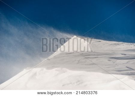 Clear and high mountain snowdrift and strong blowing wind under the bright and blue sky