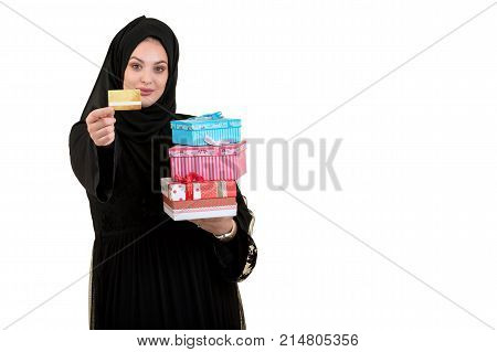 Happy young muslim woman with shopping bag and gift boxes isolated over white background.