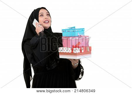 Happy young muslim woman with shopping bag and gift boxes isolated over white background.