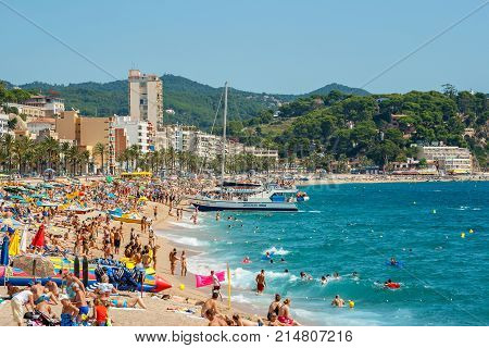 LLORET DE MAR SPAIN - SEPTEMBER 12 2007: Many people relaxing and sunbathing on sandy beach
