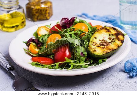 Raw arugula with vegetables and citrus. Selective focus.