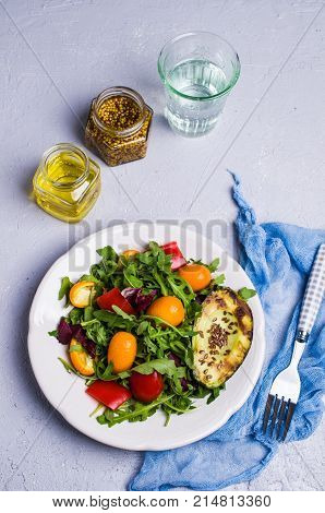 Raw arugula with vegetables and citrus. Selective focus.