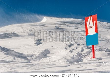 Stop signal on the background of the scenic mountain hills covered with clear white snow
