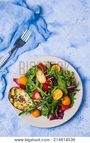 Raw arugula with vegetables and citrus. Selective focus.